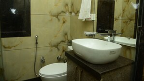 A bathroom with a white sink, a mirror, and a toilet. - Naini Hill Inn (Haldwani)