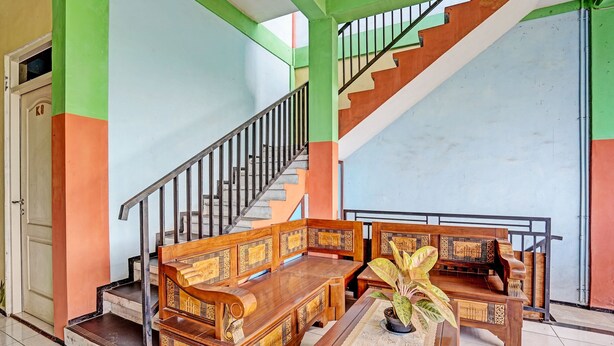 A staircase with a railing, a wooden bench, and a table with a plant.