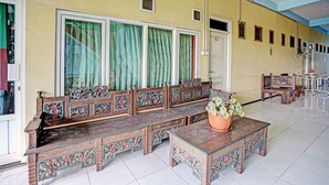 A spacious lobby with a long bench seating area, a coffee table with a potted plant, and a tiled floor.