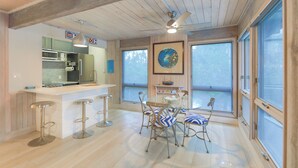 Una cocina moderna con barra, ventanas amplias y ventilador de techo.