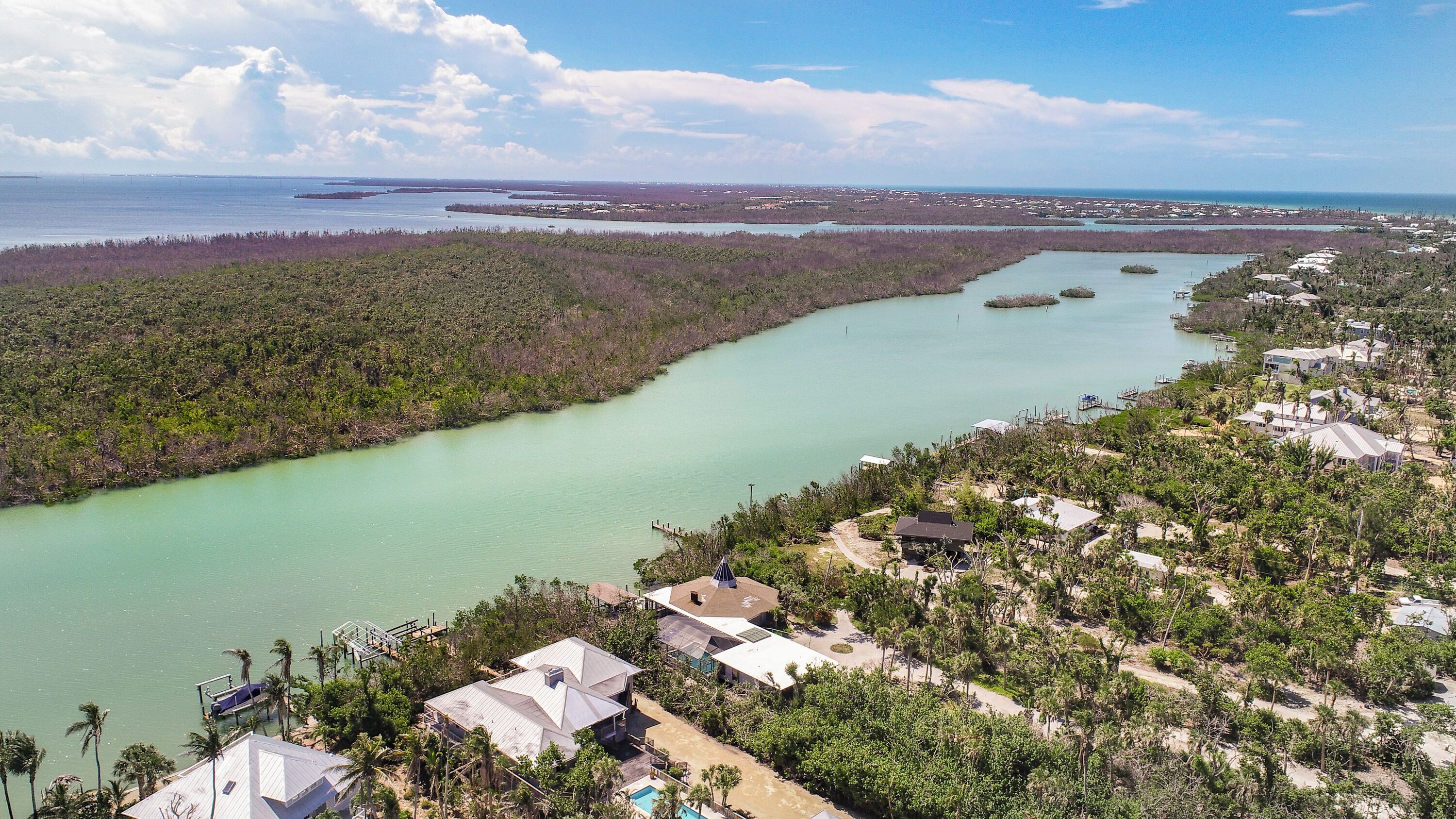 Une zone côtière avec une rivière, des maisons et un quai.