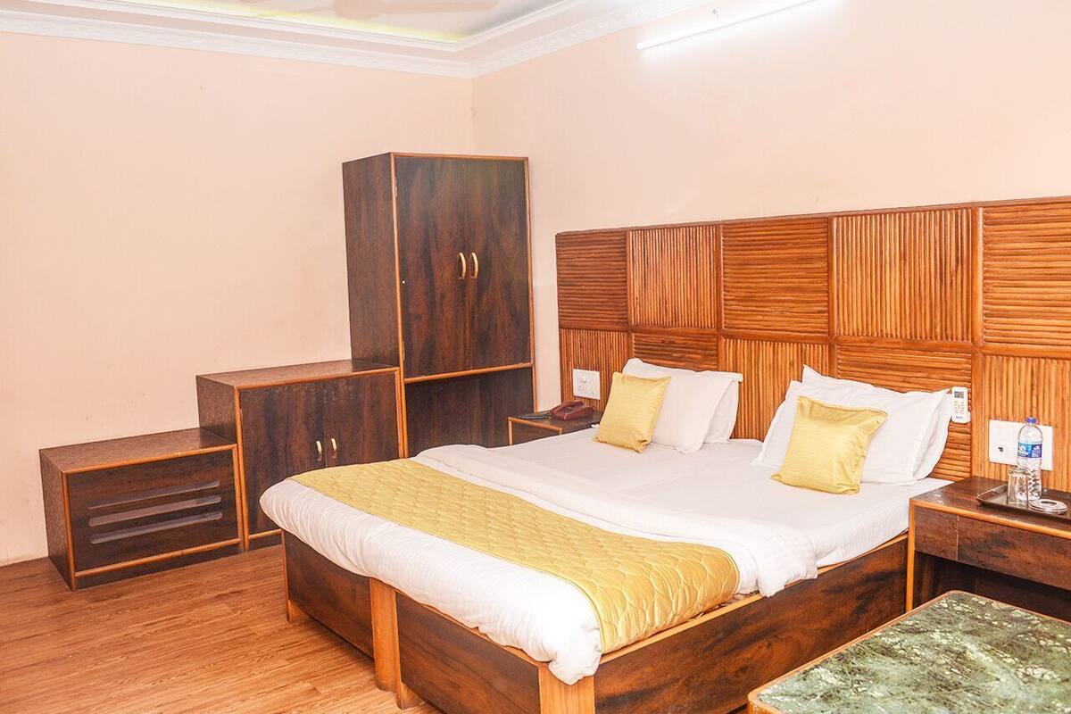 A bedroom with a wooden bed, a wardrobe, a bedside table, and a nightstand.