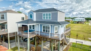 A two-story house with a covered porch and a deck. - Beachfront |Cargo Elevator | Steps to Beach | Baby+Beach Gear | Lawn+Board Games (Long Beach)