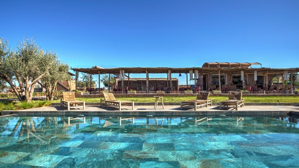 A clear pool with lounge chairs and a covered seating area. - The Ranch resort (Aghouatim)