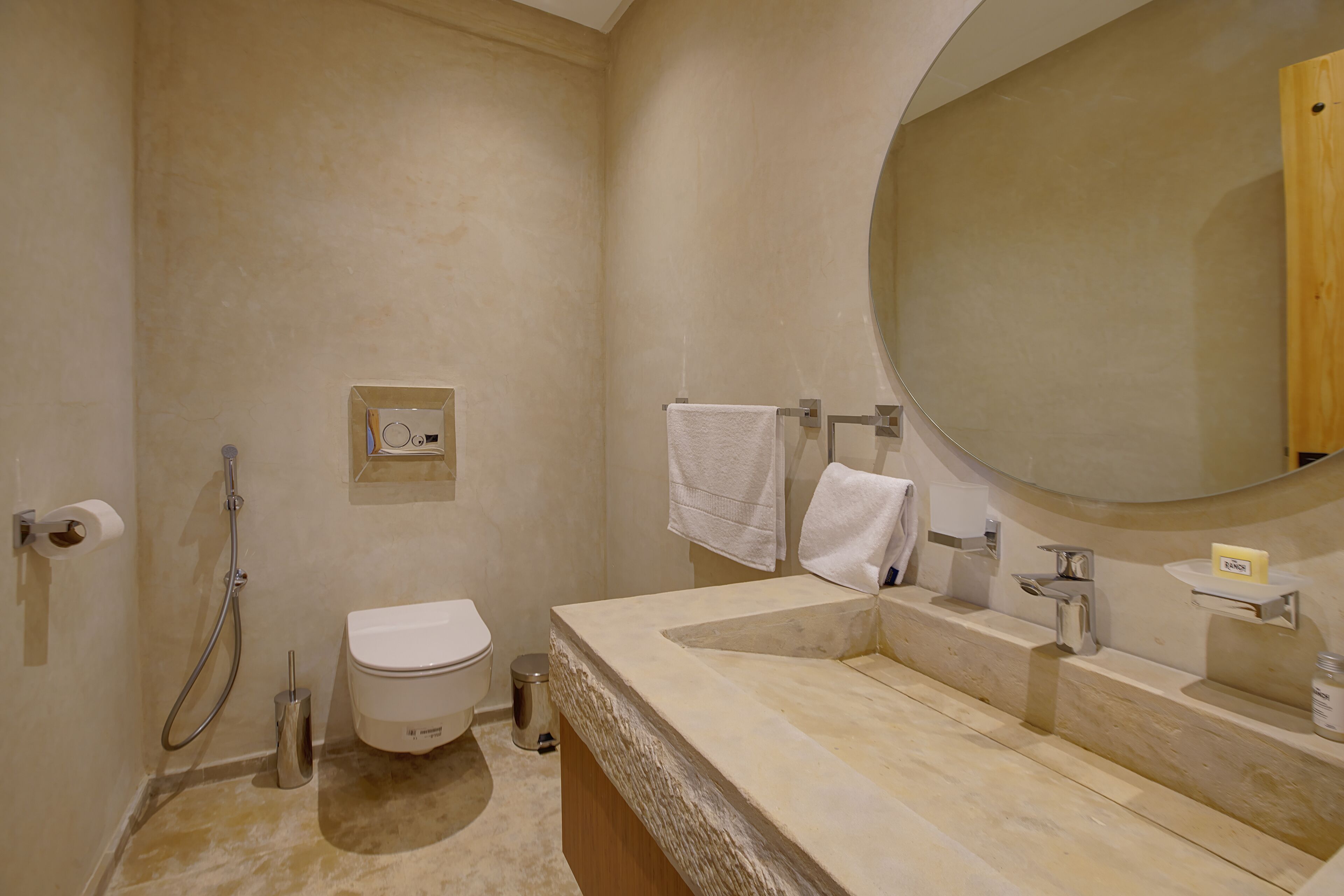 Une salle de bain avec des toilettes, un lavabo et un miroir.