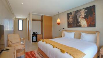 Um quarto espaçoso com uma cama grande, uma cabeceira de madeira, um quadro na parede e um tapete vermelho.