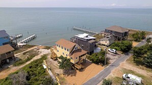 A coastal property with multiple buildings, a dock, and a road leading to the water.