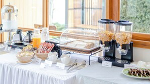 Un aparador de buffet per esmorzar amb diferents plats i una zona de cafè.
