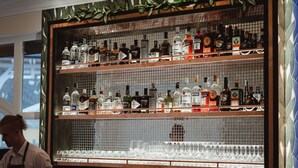 A bar with shelves of liquor bottles and glasses. - Budapest Airport Eprespark Hotel (Vecsés)