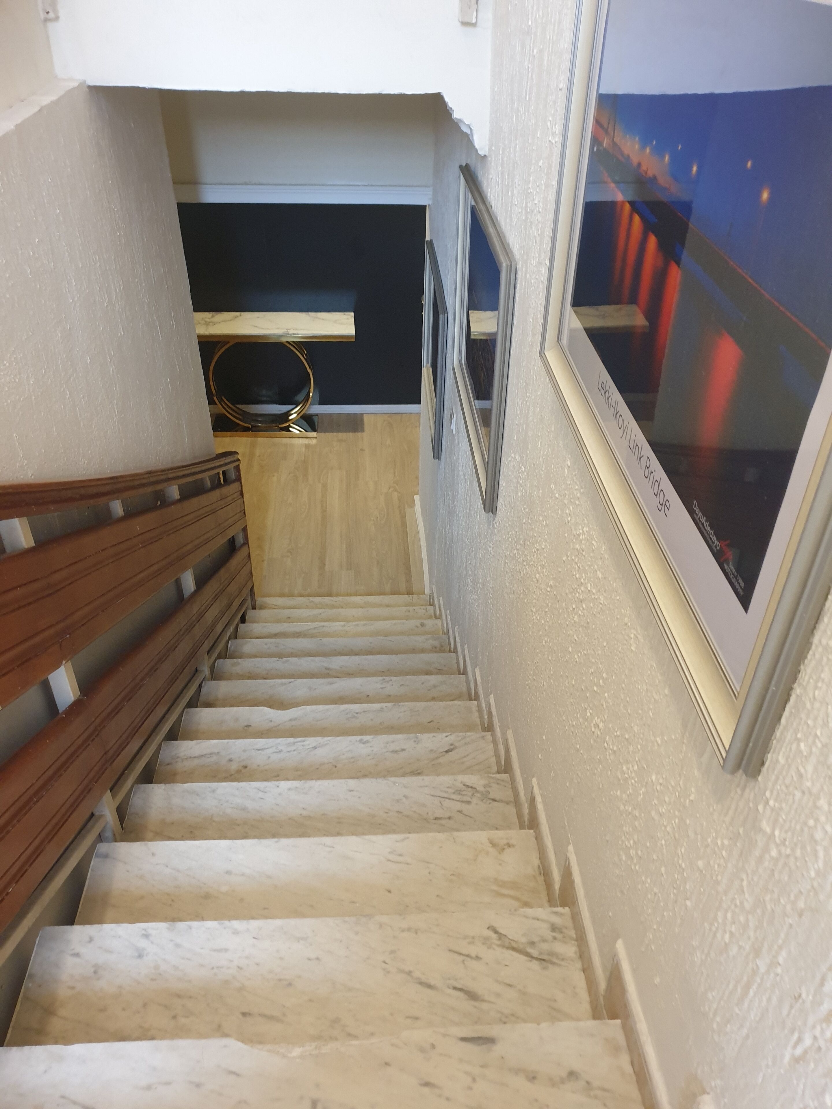 A marble staircase with wooden handrails leading to a landing.
