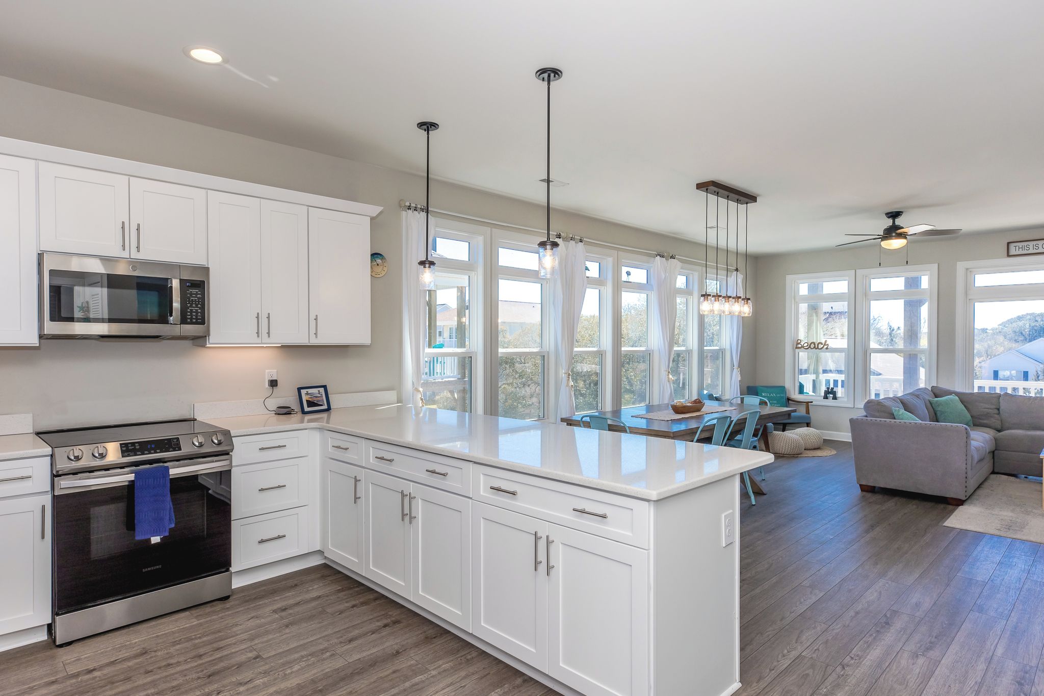 A modern kitchen with white cabinetry, a built-in microwave, and a stainless steel oven.