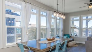 A dining area with a wooden table, blue chairs, and a chandelier.