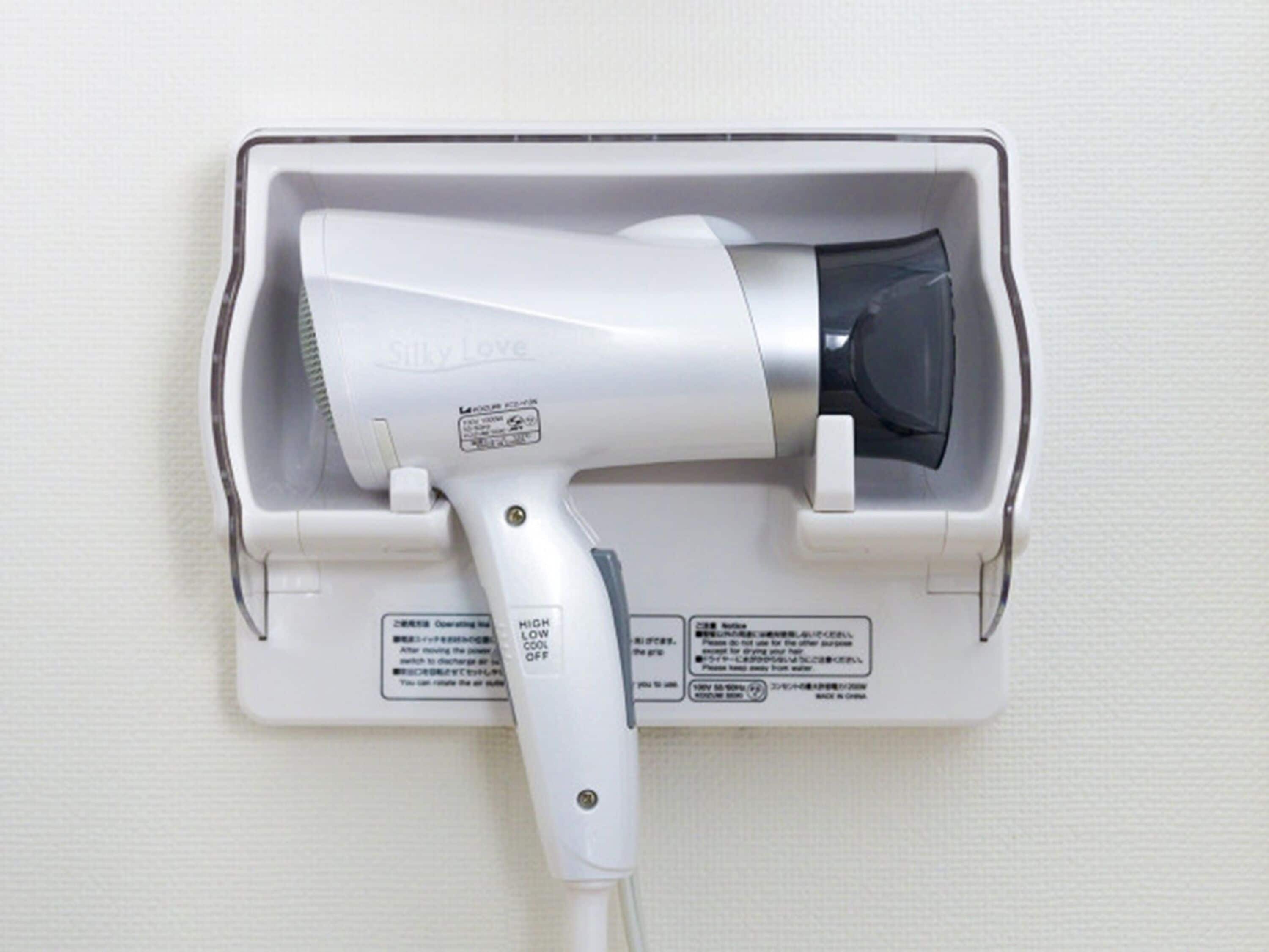 A hair dryer mounted on a wall with a control panel.