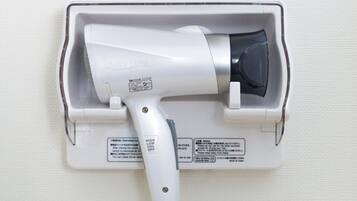A hair dryer mounted on a wall with a control panel.