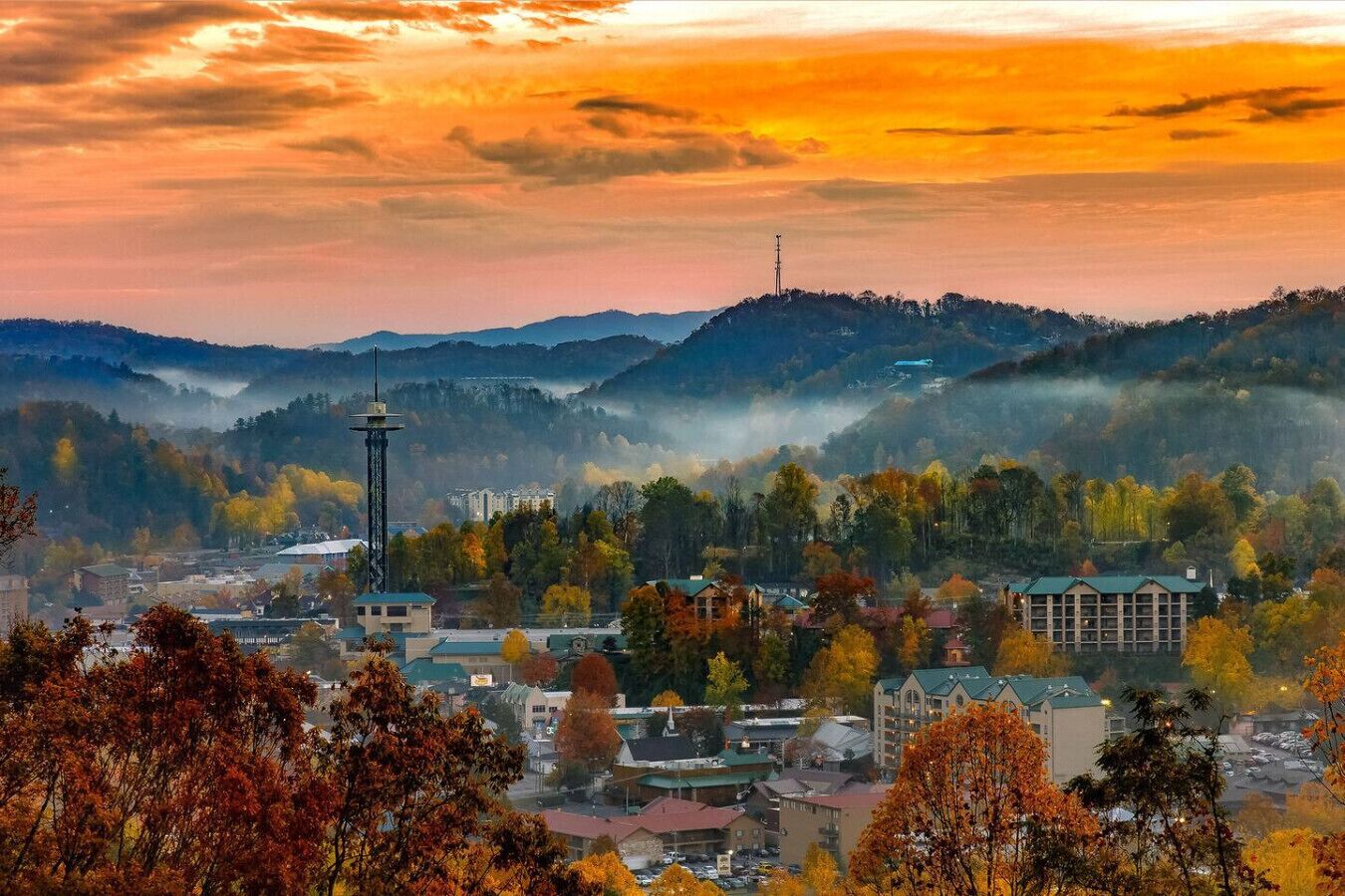 A town with autumn foliage, a prominent tower, and a mix of residential and commercial buildings.