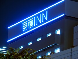 A building with a sign that reads "東懷INN" in white letters on a blue background, indicating the name of the establishment.
