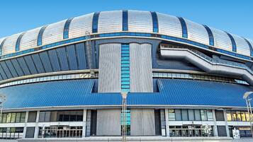 Un estadio moderno con techo curvo y amplias ventanas.