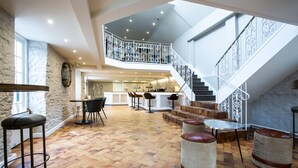 A spacious interior with a central bar area, a staircase, and a kitchen in the background. - The Hope & Anchor (Ross-on-Wye)