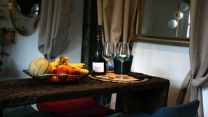 Ett bord med en vinflaska, två glas och en fruktskål.