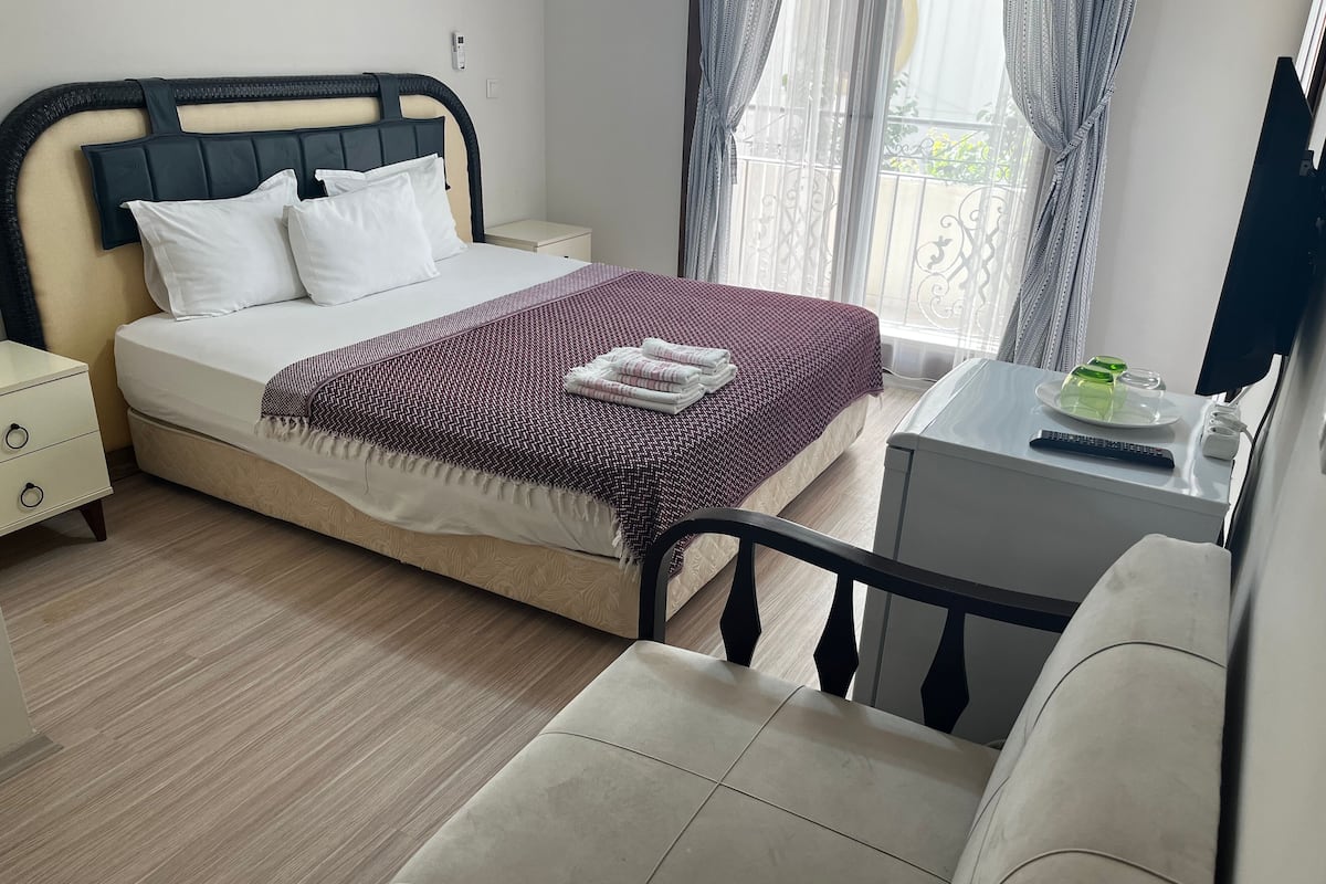 Ein ordentlich eingerichtetes Schlafzimmer mit Bett, Nachttisch und Stuhl.