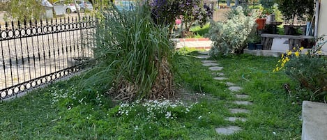 Stroll through the beautifully maintained garden, featuring a variety of vibrant flowers and lush greenery, along a winding path.