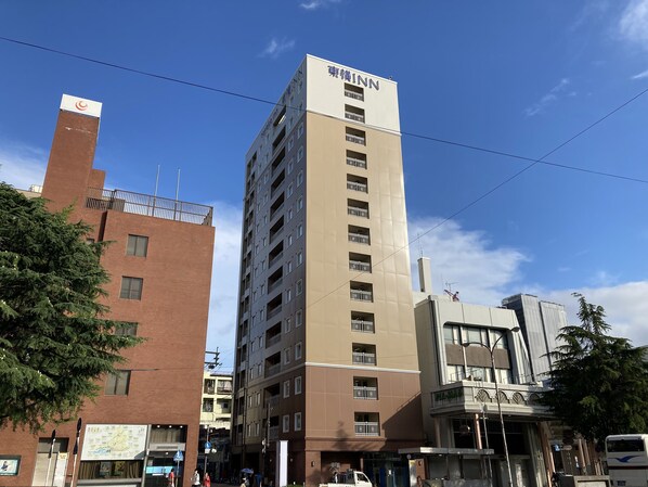 Un edificio alto con el letrero "INN" en la parte superior, que presenta varios balcones y un diseño arquitectónico moderno.
