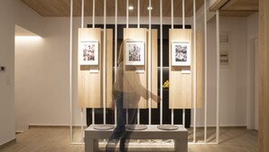 Une galerie d'art contemporain avec des panneaux en bois et des photographies encadrées.