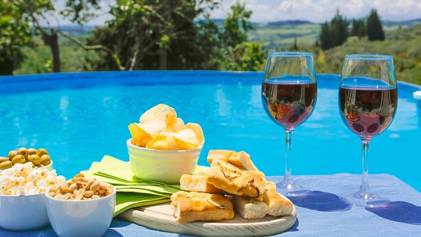 Un cadre agréable au bord de la piscine, avec des collations, deux verres de vin et une vue magnifique.