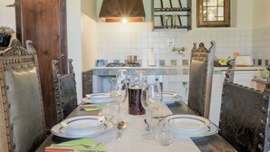 Un coin repas avec une table dressée pour quatre personnes, comprenant des assiettes, des verres et des couverts.