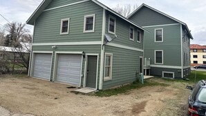 A two-story house with a garage, a satellite dish, and a driveway. - The Mountaineer Apartment - Gunnison (Gunnison)