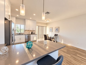 A modern kitchen with stainless steel appliances, a central island with seating, and pendant lighting. - Sonoma 2BR/2BA Condo | Full Kitchen, A/C & Views (Sonoma)