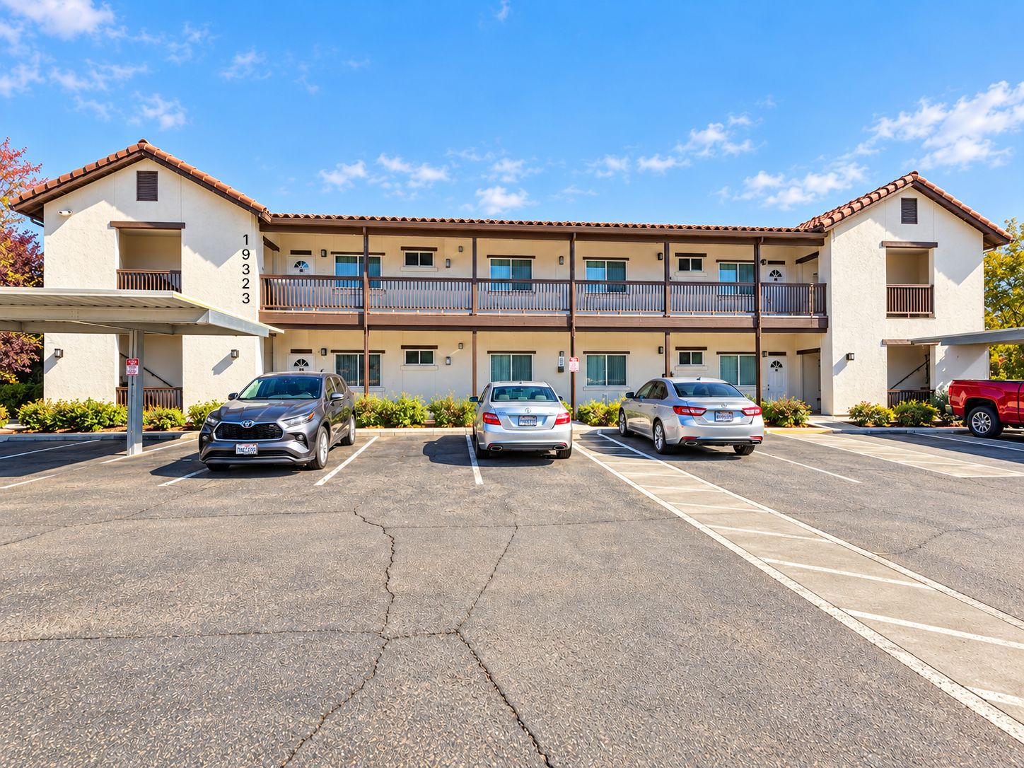 A multi-story building with a parking lot in front.