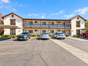 A multi-story building with a parking lot in front.
