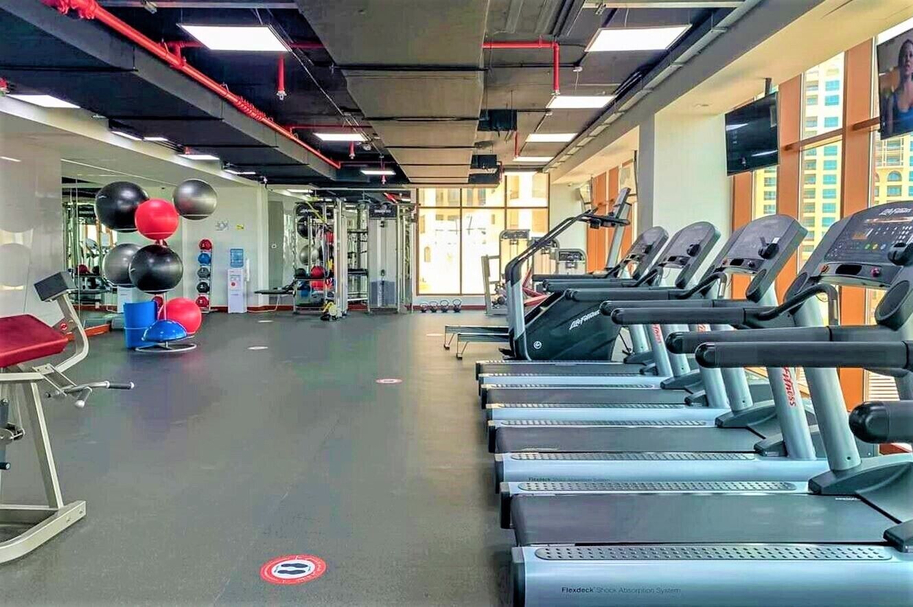A gym with treadmills, exercise balls, and weight machines.