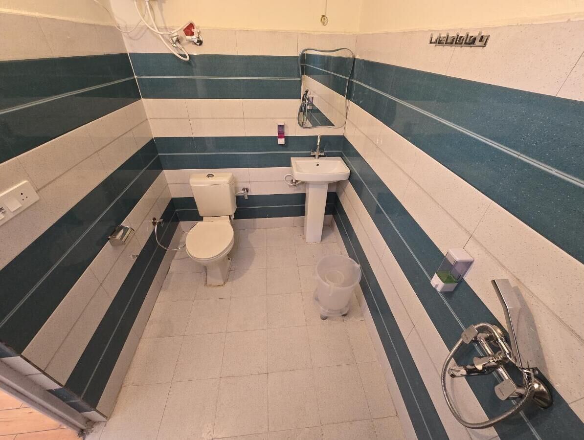 A bathroom with a toilet, sink, and shower.