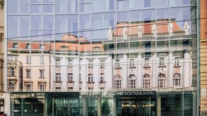 A modern hotel facade with large glass windows reflecting the surrounding architecture. - Met Boutique Hotel (Zagreb)