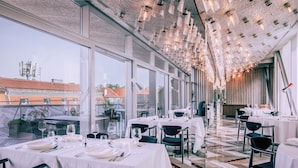 A restaurant with tables set for dining, large windows, and a ceiling with hanging lights. - Met Boutique Hotel (Zagreb)