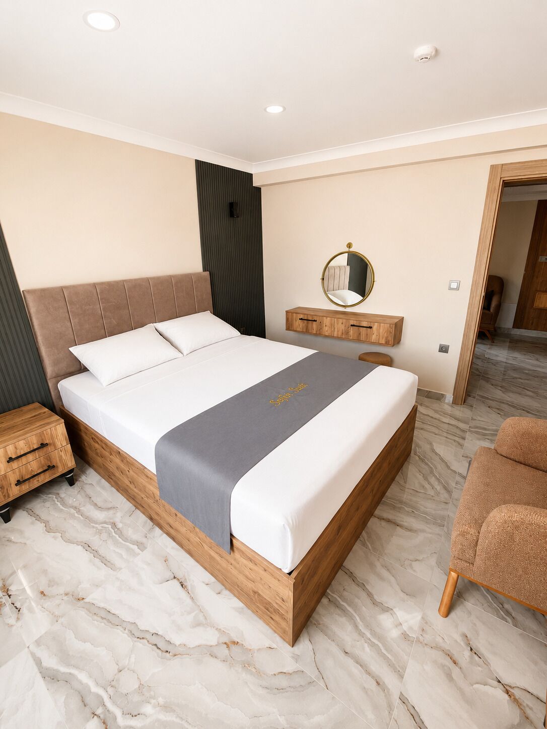 A modern bedroom with a wooden bed, a bedside table, a mirror, and a chair.