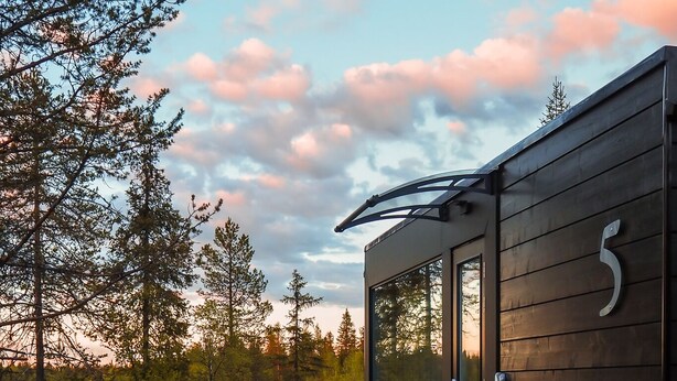 A cabin with a deck, a glass door, and a number '5' on the side.