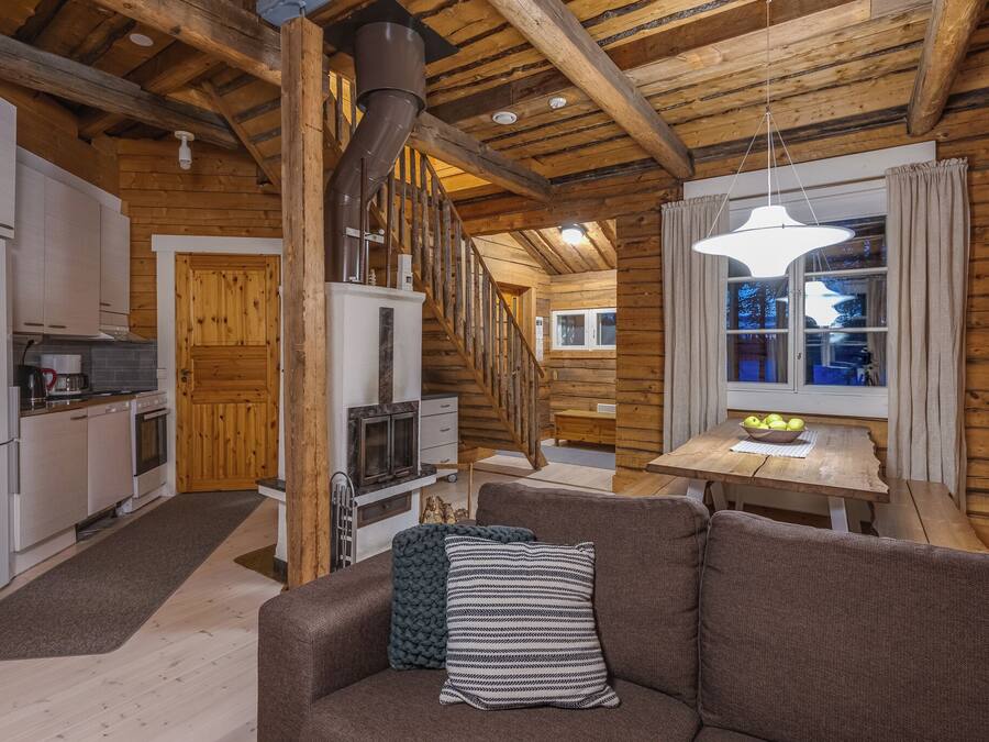 Ein gemütliches Blockhaus-Interieur mit Küche, Essbereich und einer Treppe.