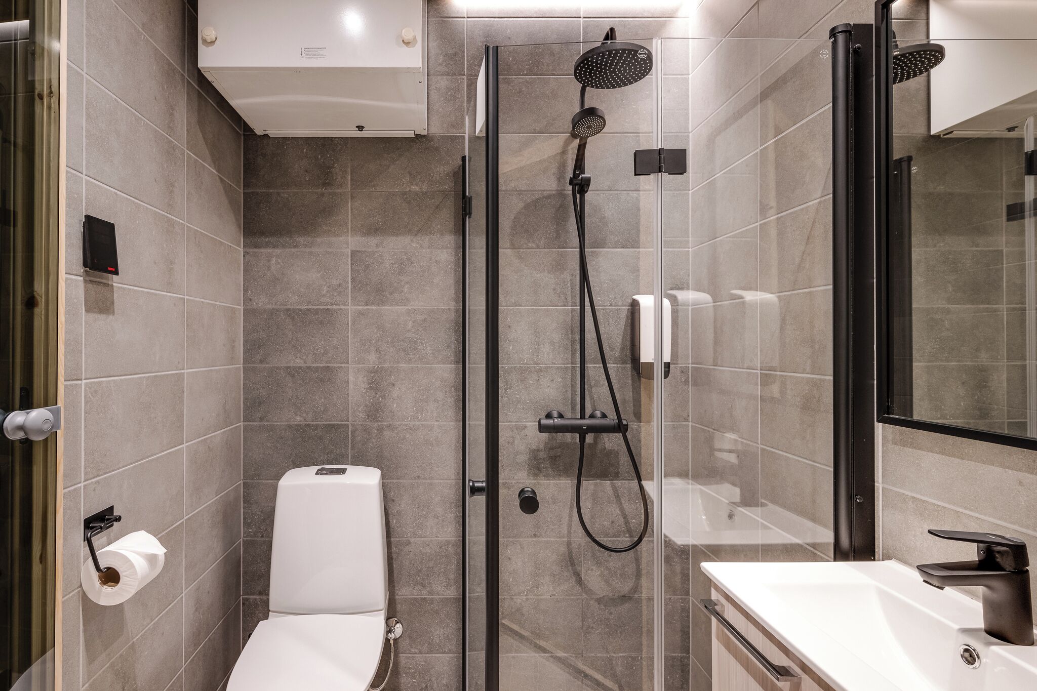 Une salle de bain moderne avec une douche à parois de verre, des toilettes et un lavabo.