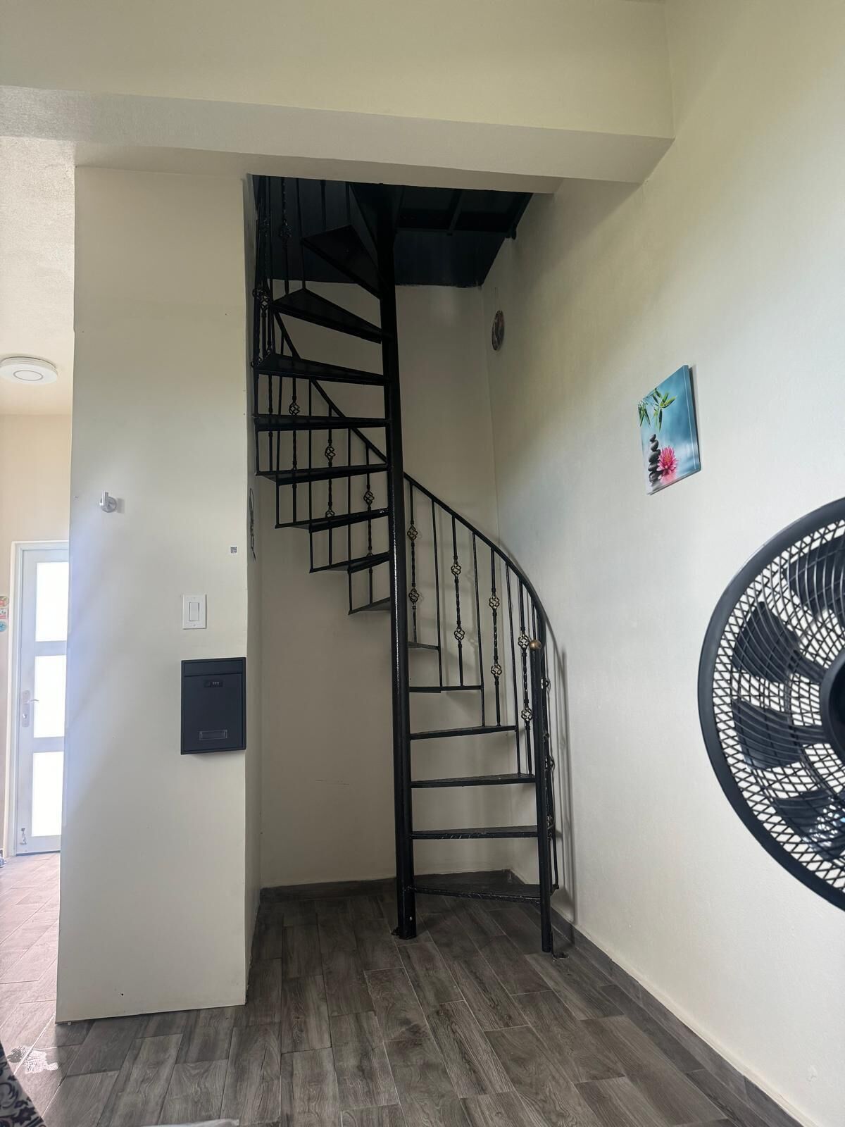 Eine Treppe mit schwarzer Metallgeländer, die zu einer oberen Etage führt.