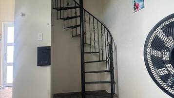 Eine Treppe mit schwarzer Metallgeländer, die zu einer oberen Etage führt.