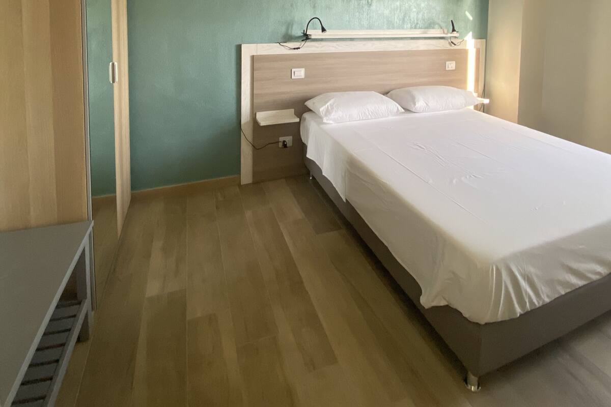 Une chambre à coucher comprenant un lit, une table de chevet, une commode et une armoire.