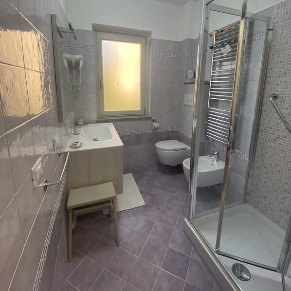 A bathroom with a bathtub, toilet, and shower area. - Vatikurca (San Nicola Arcella)