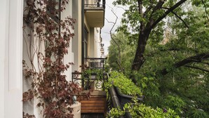 A narrow pathway flanked by lush greenery and a building with a wooden bench and potted plants. - Lux West-side, Central Oslo - 4bedrooms/8sleep/close to everything  (Frogner)