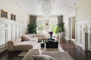 A spacious living room with a large sectional sofa, a coffee table, and a chandelier. - Lux West-side, Central Oslo - 4bedrooms/8sleep/close to everything  (Frogner)