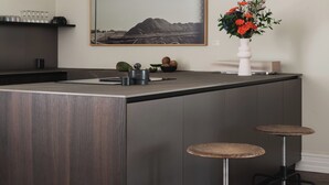 A modern kitchen with a central island, bar stools, a chandelier, a framed landscape painting, and a vase with flowers. - Lux West-side, Central Oslo - 4bedrooms/8sleep/close to everything  (Frogner)