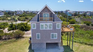 A two-story house with a balcony, a deck, and a fenced yard.