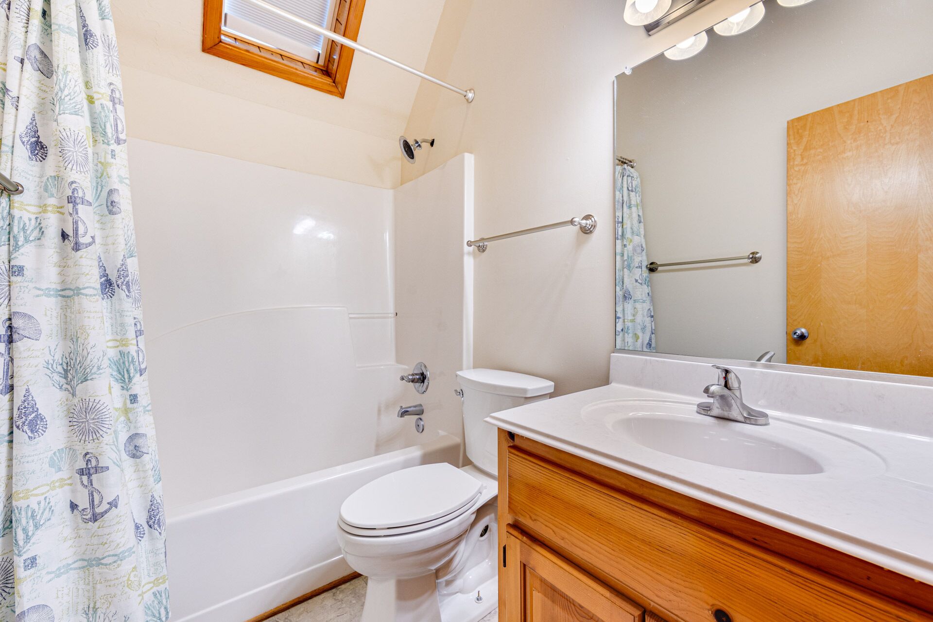 A bathroom with a bathtub, toilet, and sink.